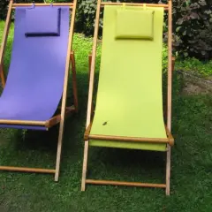 Dwa leżaki ogrodowe, jeden fioletowy, drugi zielony, czekają na wymianę materiału.