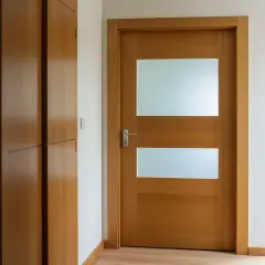Nowoczesne drzwi z szybą, jak przerobić stare drzwi z szybą na nowoczesne. Drewniane drzwi z dwoma przeszkleniami i metalową klamką.