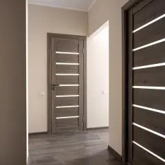 Nowoczesne drzwi z poziomymi przeszkleniami, idealne do otworu pod drzwi 80. Drewnopodobne, ciemne skrzydła dodają elegancji.