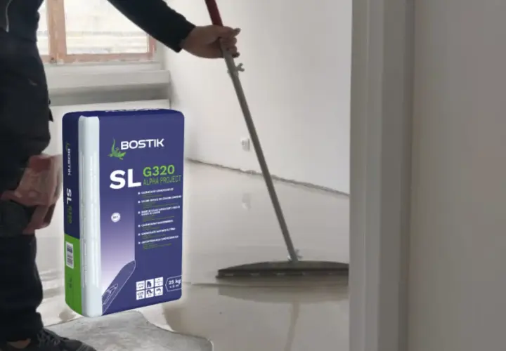 Pracownik rozlewa masę samopoziomującą Bostik SL G320, by wyrównać posadzkę.