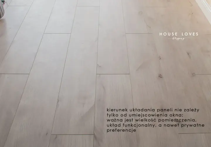 Jasne panele podłogowe ułożone równolegle do okna.