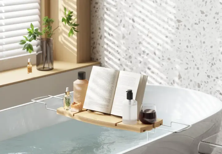 Relaks w wannie jak w spa: książka, kosmetyki i napój na tacce. Idealne miejsce na odprężenie.