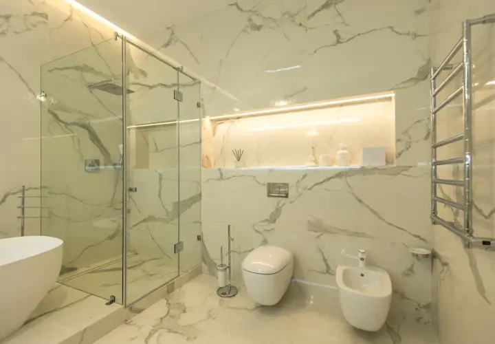 Nowoczesna łazienka z prysznicem walk-in i wanną. Ściany i podłoga wykończone wielkoformatowymi płytkami imitującymi marmur. Eleganckie rozwiązanie co zamiast płytek pod prysznic.
