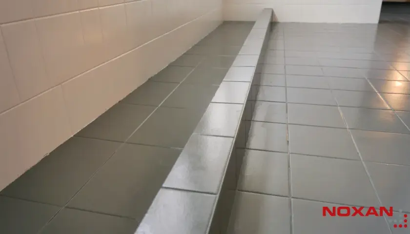 Szare płytki podłogowe z połyskiem, idealne do łazienki. Zastanawiasz się, czym pomalować płytki podłogowe? Sprawdź nasze rozwiązania.
