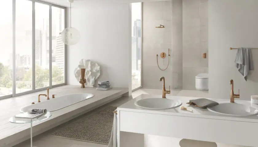 Elegancka łazienka z wanną i dwiema umywalkami, gdzie armatura Grohe i Hansgrohe w kolorze miedzi tworzy spójną całość.