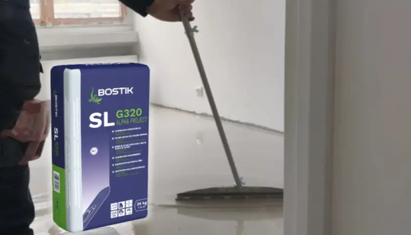 Pracownik rozlewa masę samopoziomującą Bostik SL G320, by wyrównać posadzkę.
