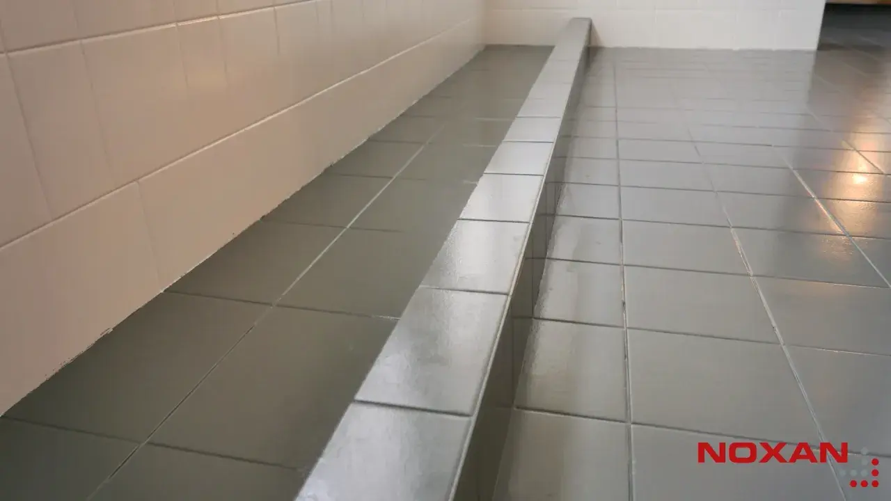 Szare płytki podłogowe z połyskiem, idealne do łazienki. Zastanawiasz się, czym pomalować płytki podłogowe? Sprawdź nasze rozwiązania.