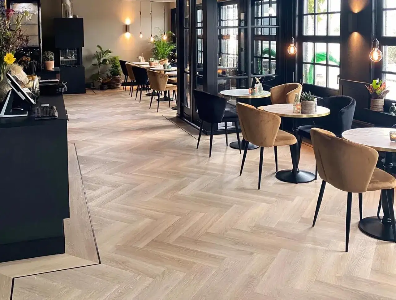 Eleganckie wnętrze restauracji z podłogą w jodełkę, która pokazuje, jak wyglądają panele winylowe.
