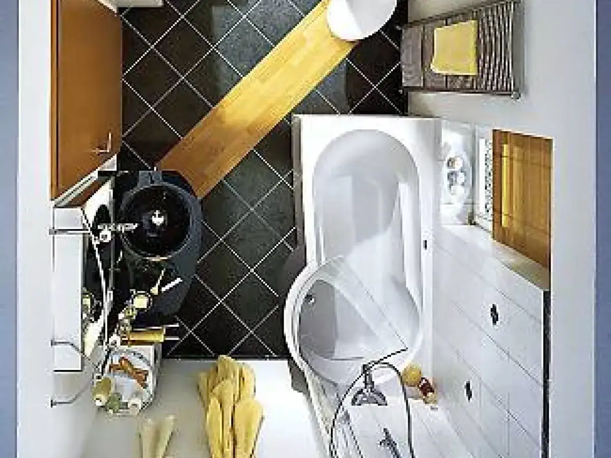 Kompaktowa łazienka z wanną, czarną umywalką i drewnianymi akcentami.