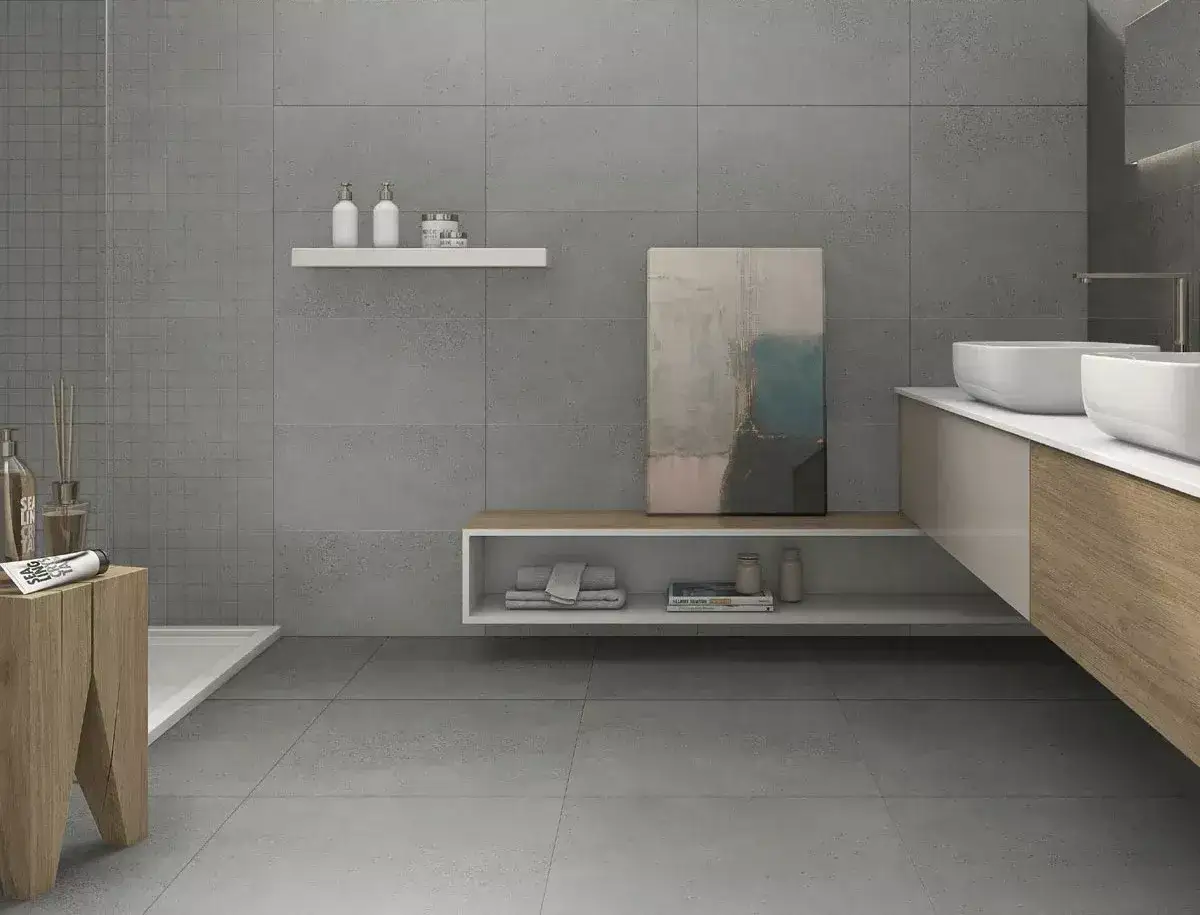 Nowoczesna łazienka z szarymi, wielkoformatowymi płytkami bez fugi. Minimalistyczny design, podwójna umywalka i drewniane akcenty.